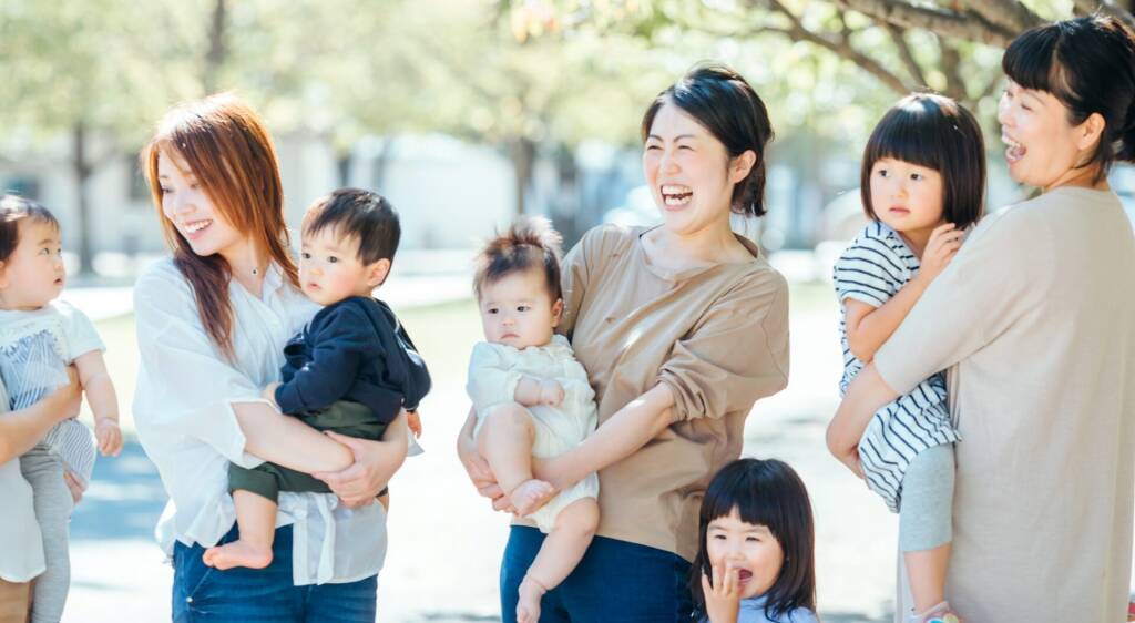 母親と子どもたちの笑顔が広がる育児と多様性を象徴する一枚 | my stellaマイステラブログ|子どもの好きが育つヒントと親子の時間 笑顔の母親たちと子どもたちが外で楽しく過ごしている様子