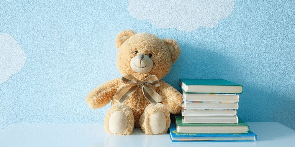 想像力を育む特別な存在 | my stellaマイステラブログ|子どもの好きが育つヒントと親子の時間 空色の壁を背景に置かれた、クマのぬいぐるみと絵本