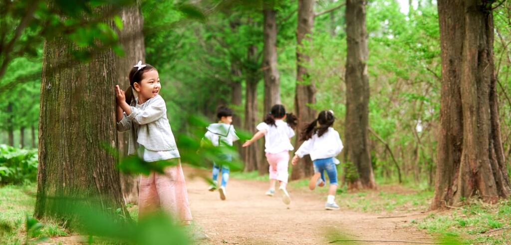 公園で忍者になりきりかくれんぼ遊びをする子どもたち 公園の木立の中で忍者ごっこをして遊ぶ子どもたち。木に隠れながら走り回り、想像力をふくらませている様子