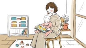 出産祝いの絵本を膝の上の赤ちゃんと一緒に読むママの温かい様子